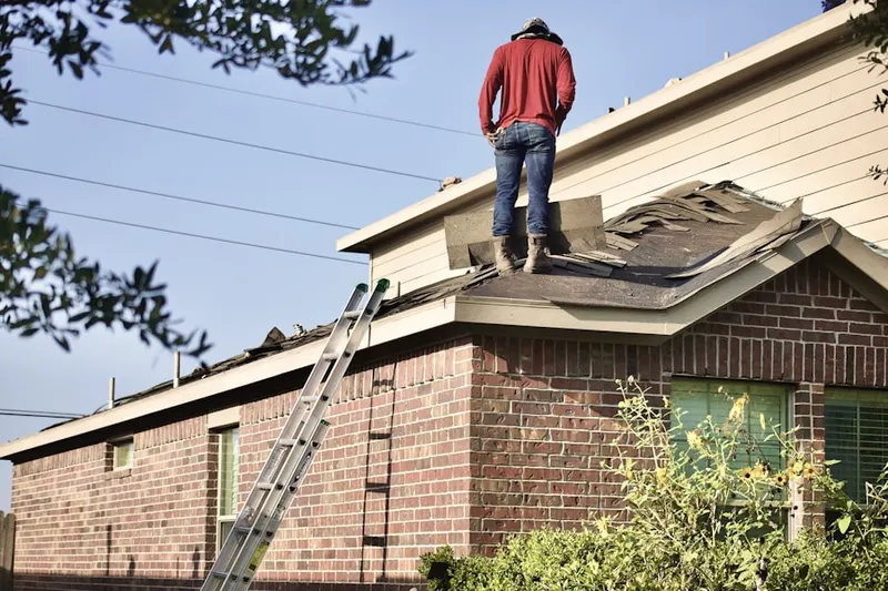 Professional roofer working on a residential roof in Arthur